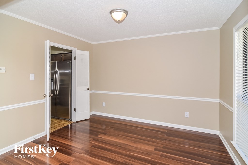 A room with a wooden floor and a white door.