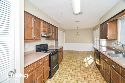 A kitchen with wooden cabinets and a tiled floor.