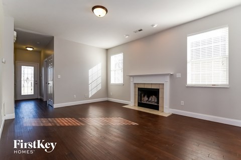 a living room with a fireplace and wooden floors