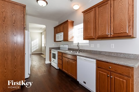 a kitchen with wood cabinets and white appliances and a counter top