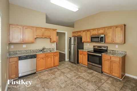 a kitchen with wooden cabinets and stainless steel appliances