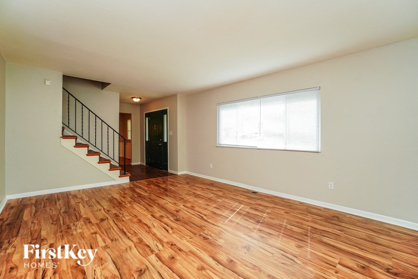 the living room with hardwood floors and a large window