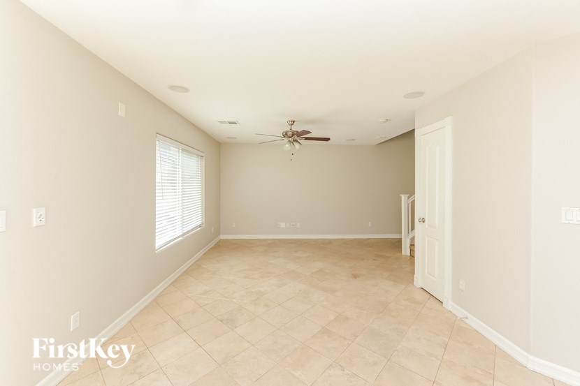 a empty living room with a ceiling fan