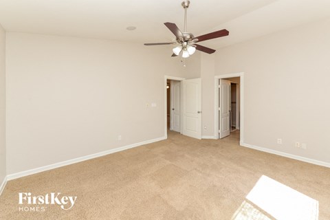 a living room with carpet and a ceiling fan