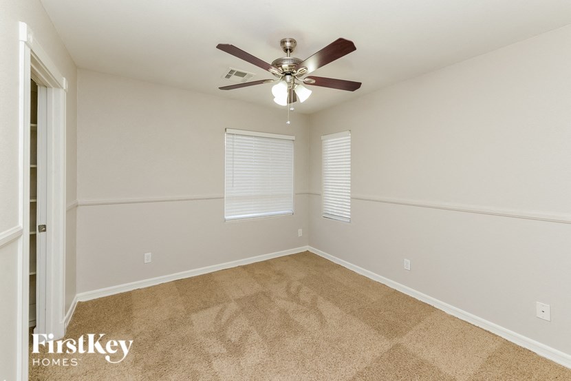 a bedroom with a ceiling fan and a window