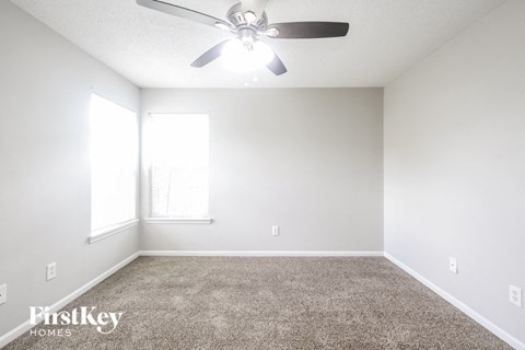 a bedroom with a ceiling fan and a carpeted floor