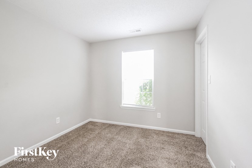 an empty room with carpet and a window