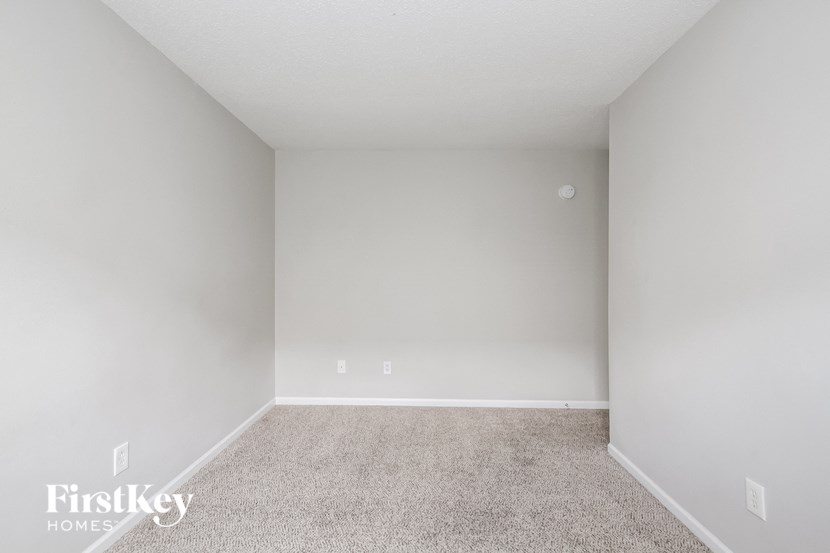 an empty room with carpet and white walls
