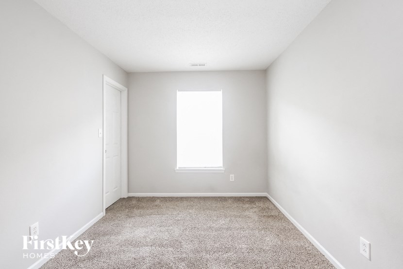 a white room with a window and carpet