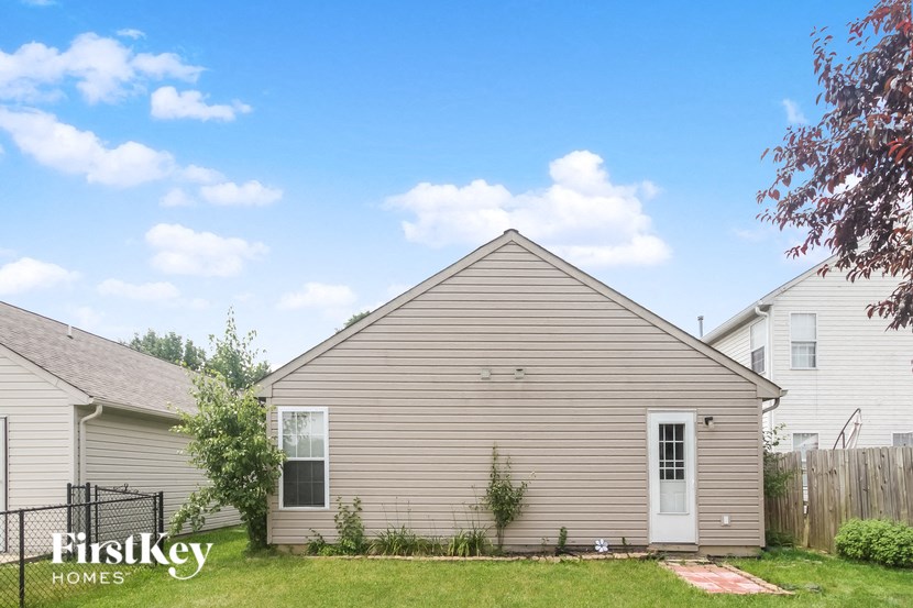 the outside of a house with a yard and a fence