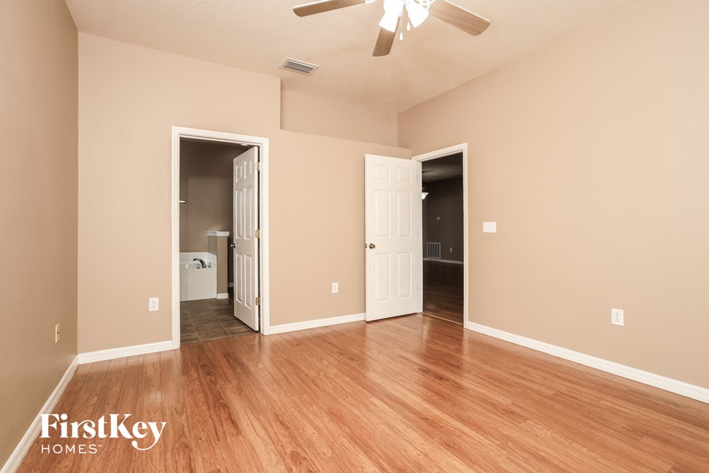 A room with a wooden floor and a ceiling fan.