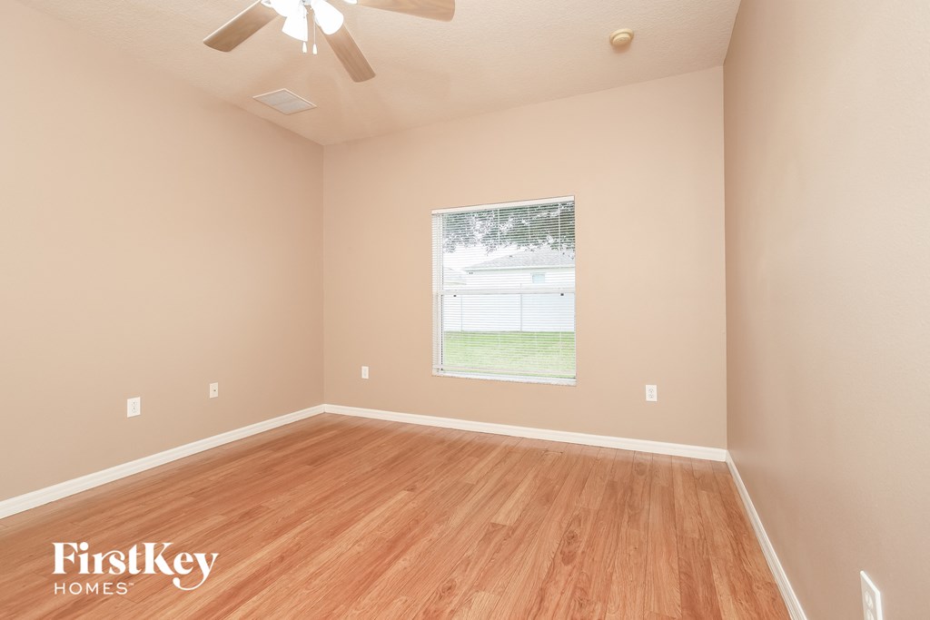 A room with wooden flooring and a ceiling fan.