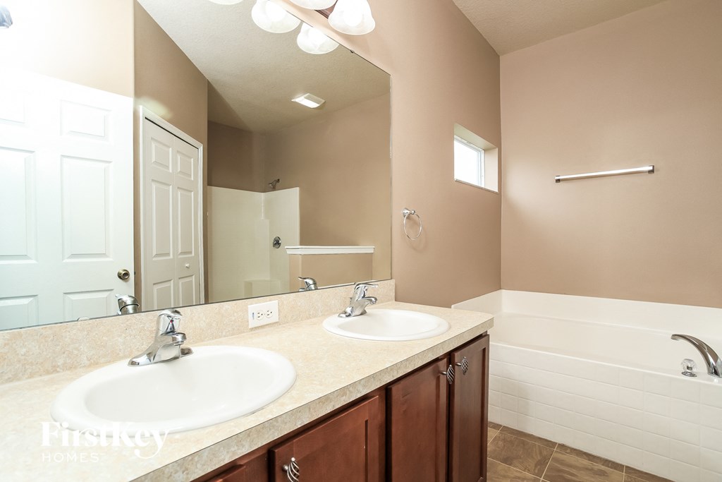 A bathroom with a double sink vanity and a bathtub.