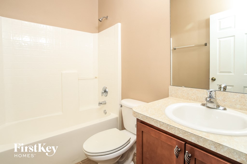A bathroom with a toilet, sink, and bathtub.