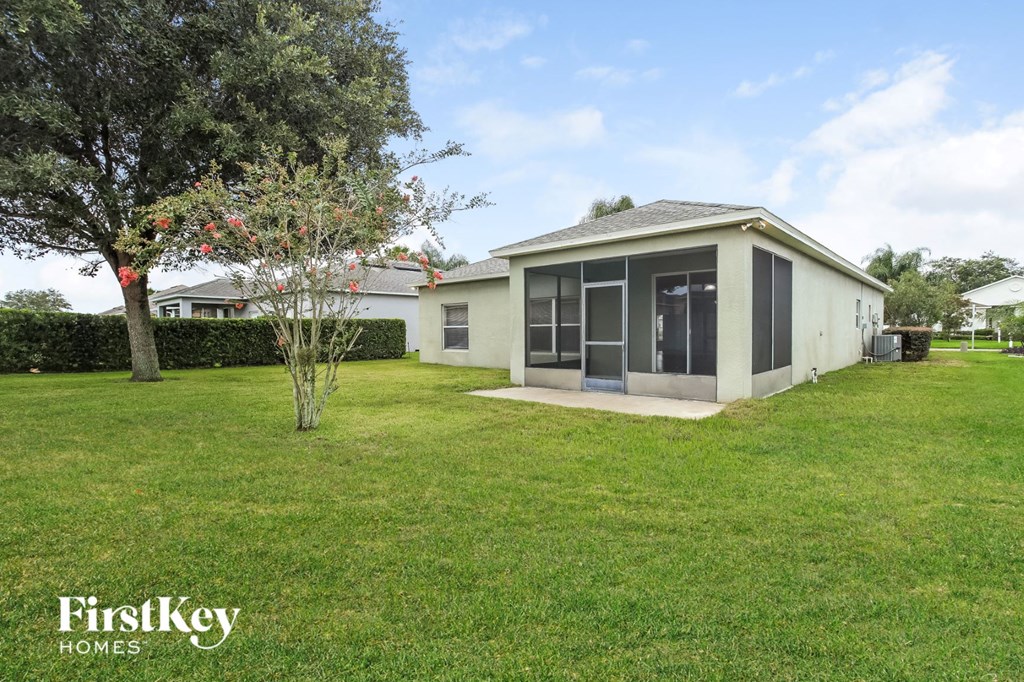 A house with a lawn and a tree in front of it.