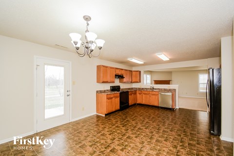 A kitchen with a tile floor and wooden cabinets.