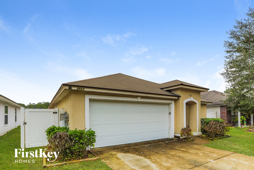 A house with a brown roof and a white garage door is for sale.