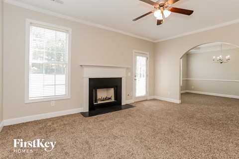 a living room with a fireplace and a ceiling fan