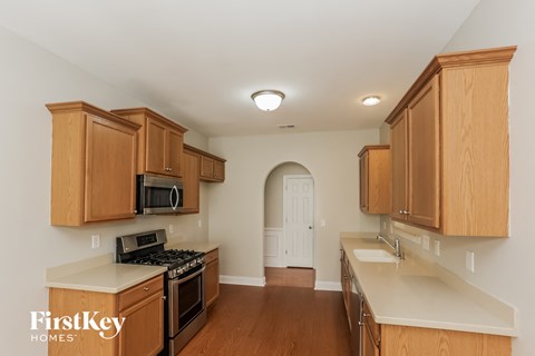 a kitchen with wooden cabinets and white counter tops and a stove top oven