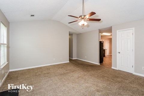 a living room with carpet and a ceiling fan