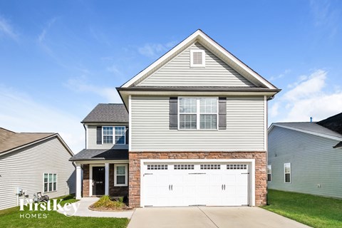A two-story house with a garage is for sale.