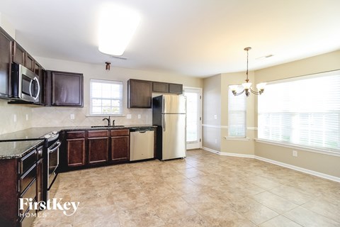 A kitchen with brown cabinets and a black counter top.
