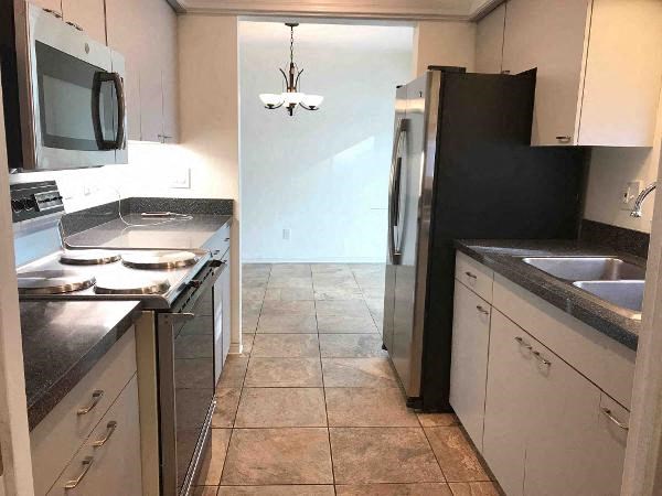 A kitchen with black appliances and white cabinets.