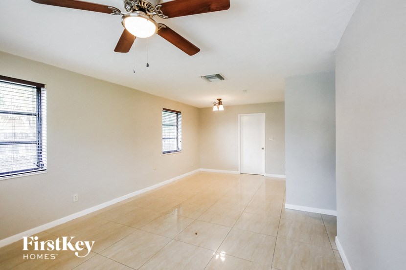 an empty living room with a ceiling fan
