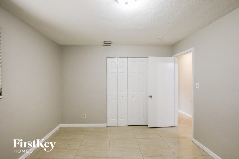 a living room with a white door and a tiled floor