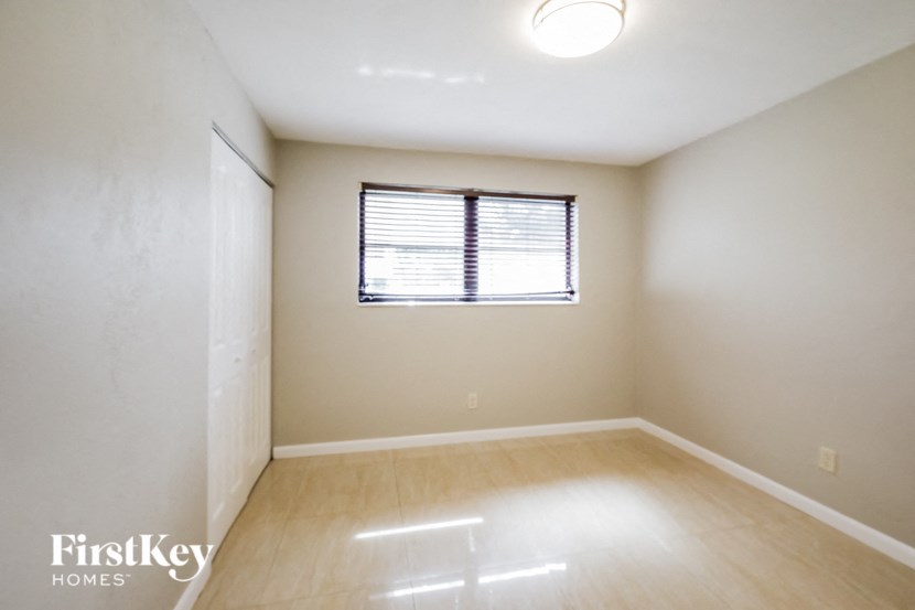 an empty room with a window and wooden floors