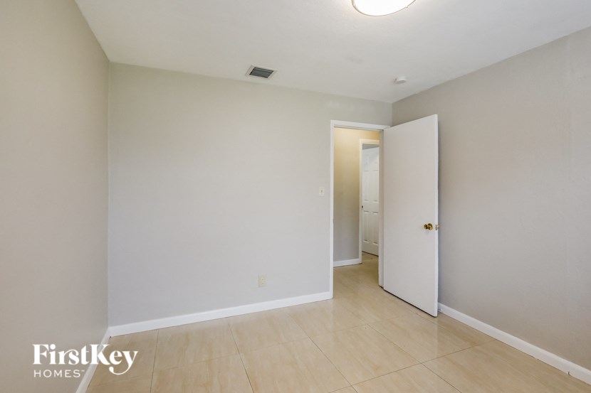 a empty room with a hallway and a door to a closet