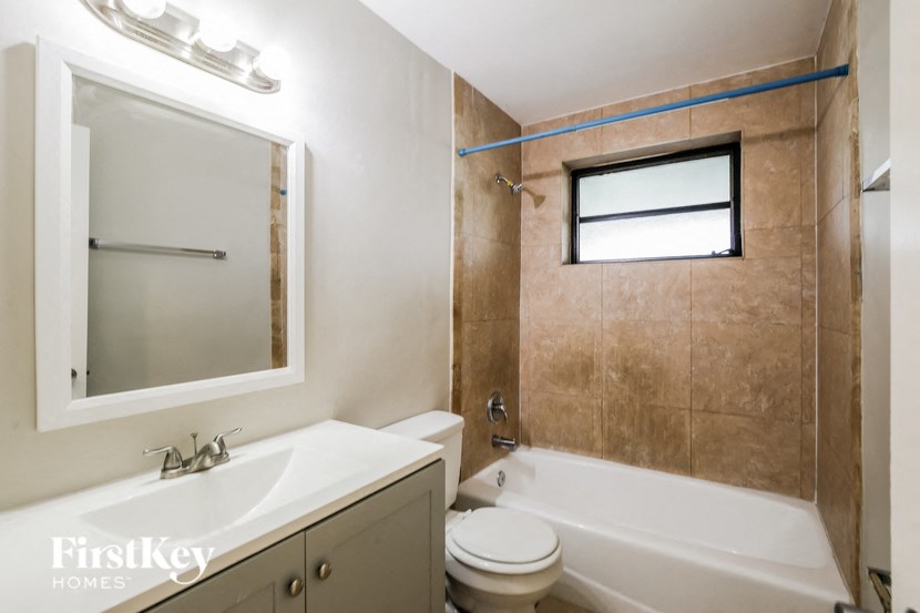 a bathroom with a tub sink toilet and a mirror