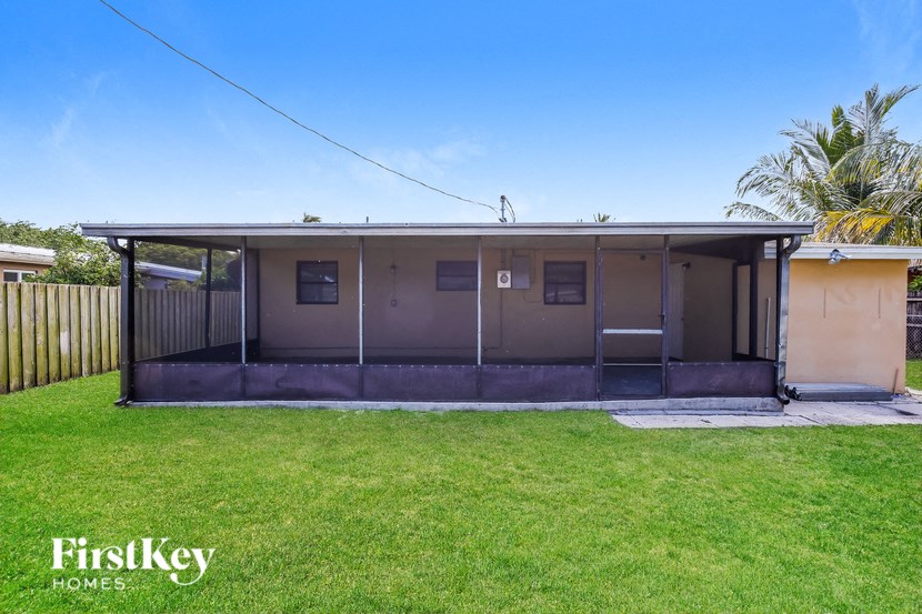 a small house with a lawn and a fence