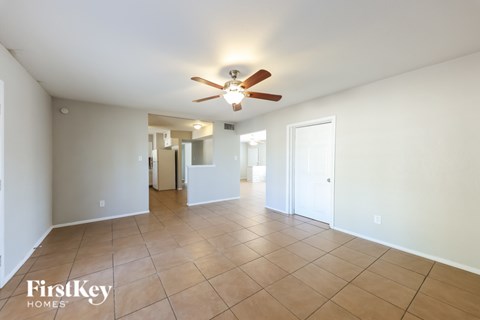 A spacious room with a ceiling fan and tiled flooring.