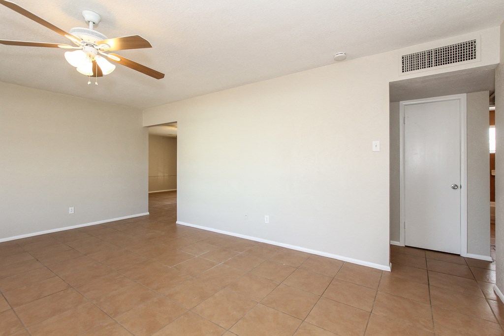 A room with a ceiling fan and tile flooring.