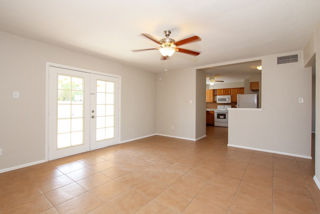 A room with a ceiling fan and tile flooring.