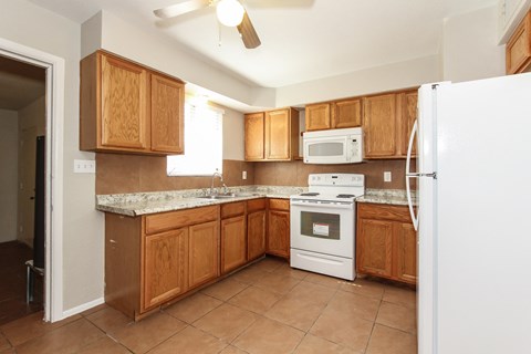 A kitchen with wooden cabinets and a white refrigerator.