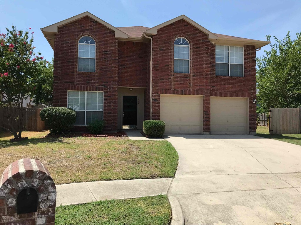 A red brick house with a white garage door.