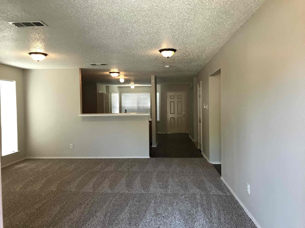 A long hallway with carpeted floors and white walls.