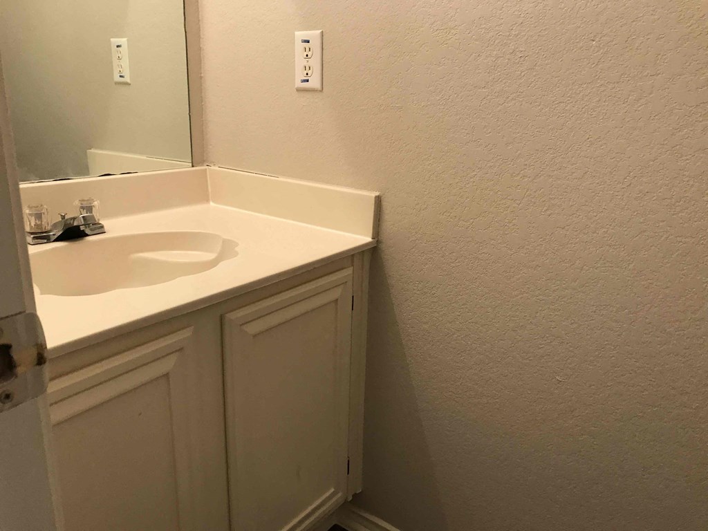A white bathroom sink with a mirror above it.