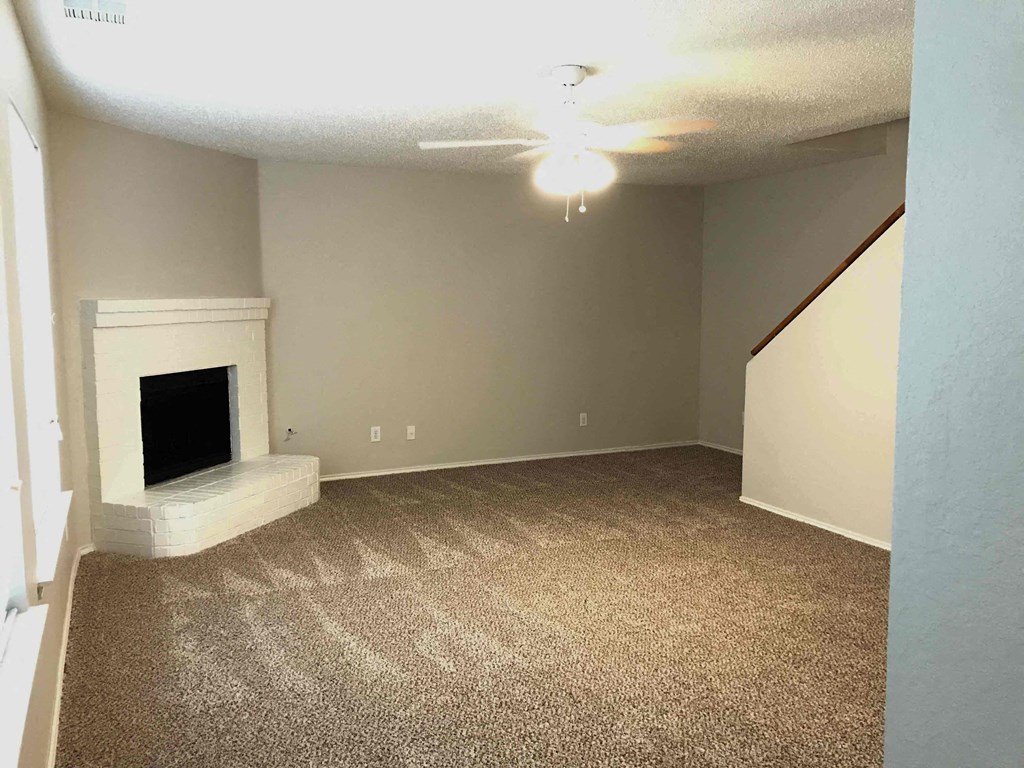 A room with a fireplace and carpeted floor.