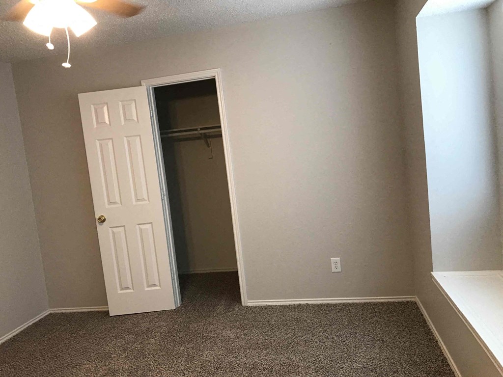 A room with a white door and carpeted floor.