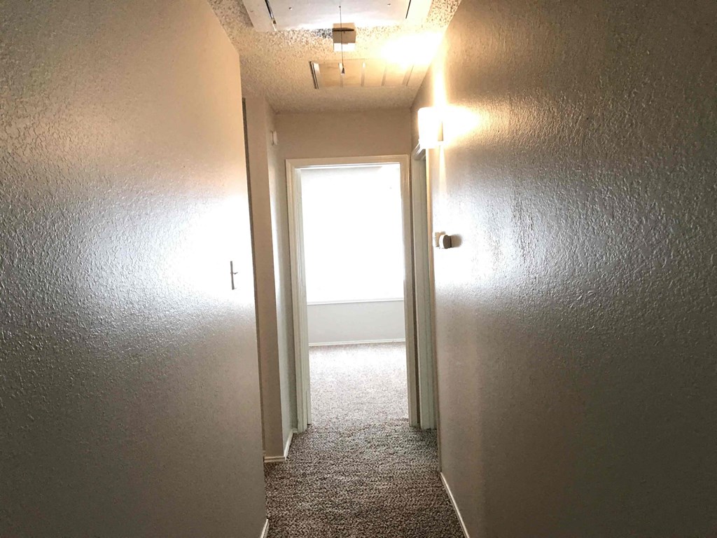 A hallway with a door at the end.