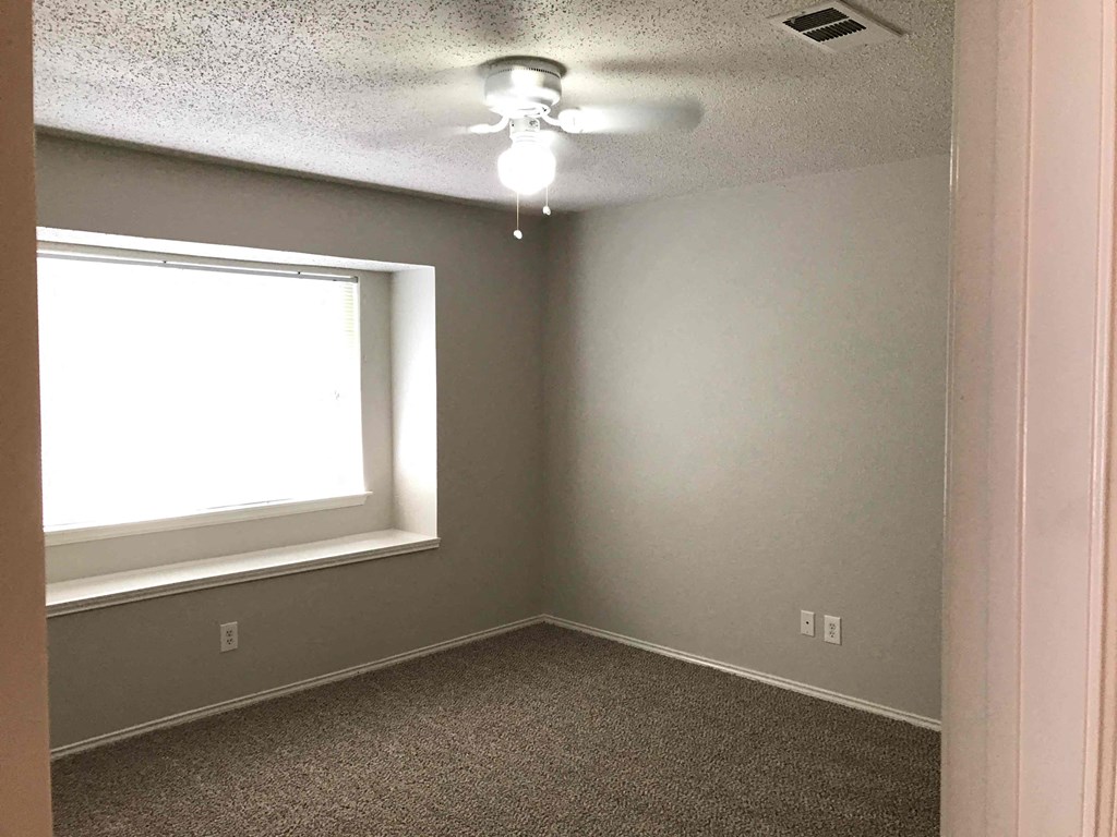 A room with a window and a ceiling fan.