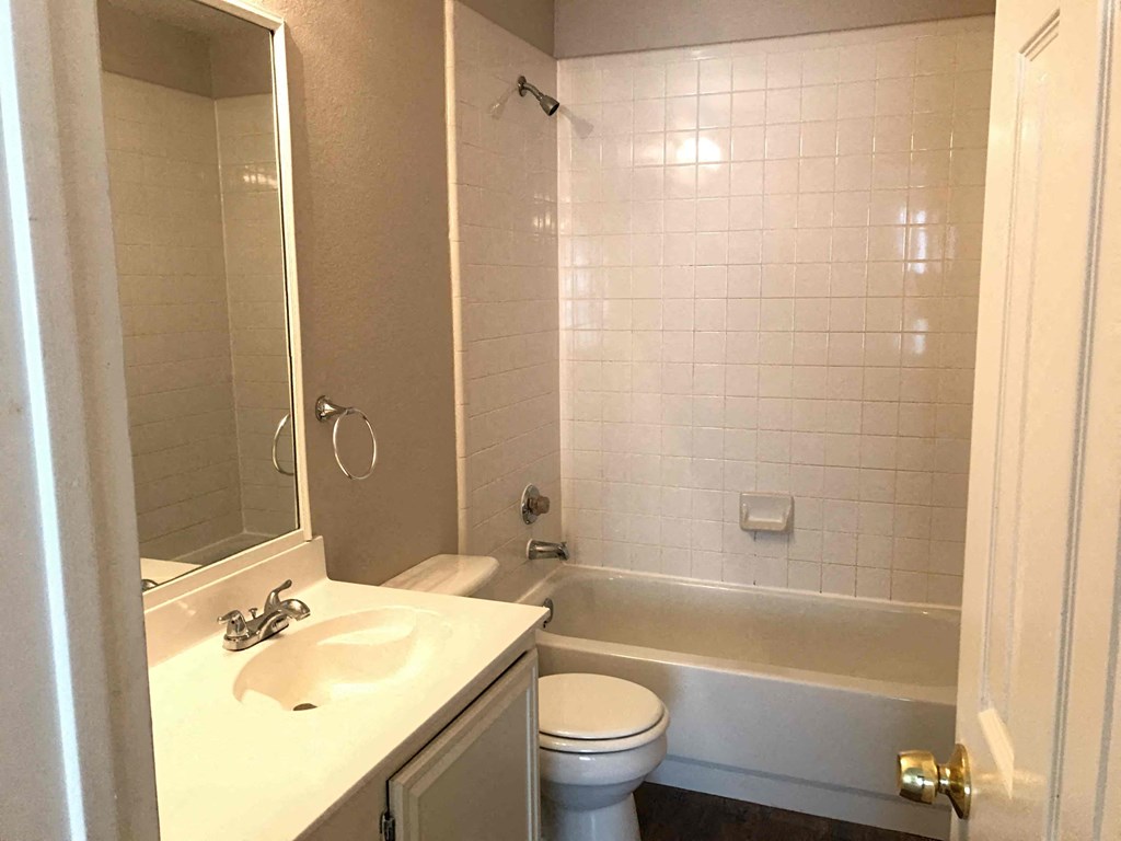 A white bathroom with a toilet, sink, and bathtub.