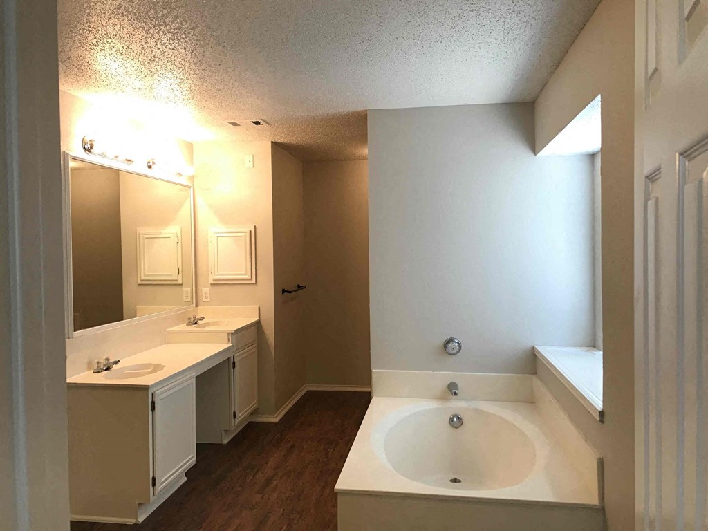 A bathroom with a white sink and a large mirror.