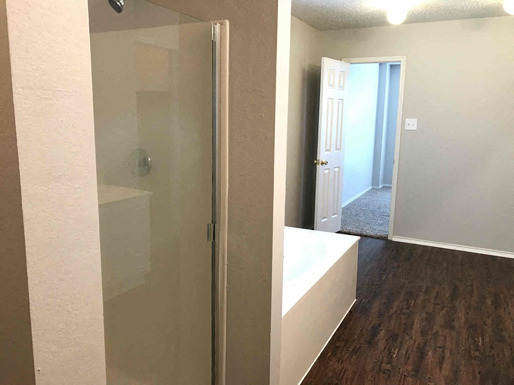 A room with a glass door and a wooden floor.