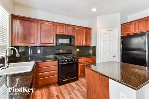 A kitchen with wooden cabinets and black appliances.
