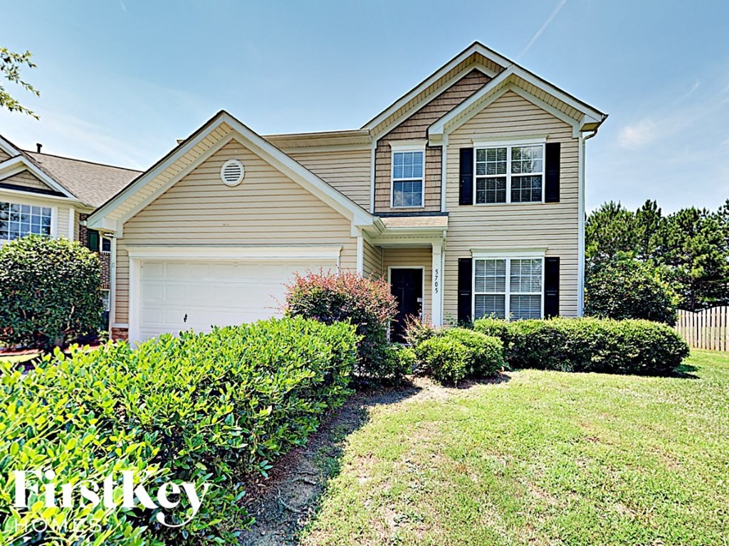 A house with a well-maintained lawn and a clear sky.
