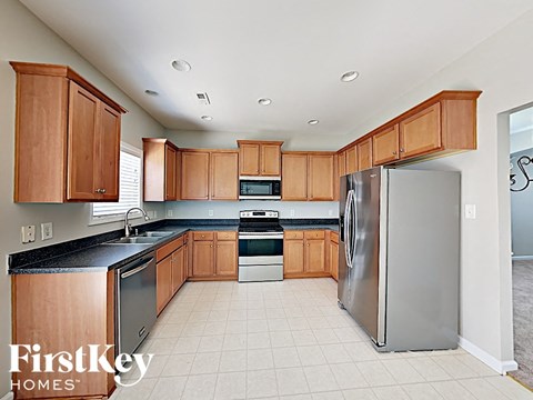 A kitchen with wooden cabinets and a refrigerator.